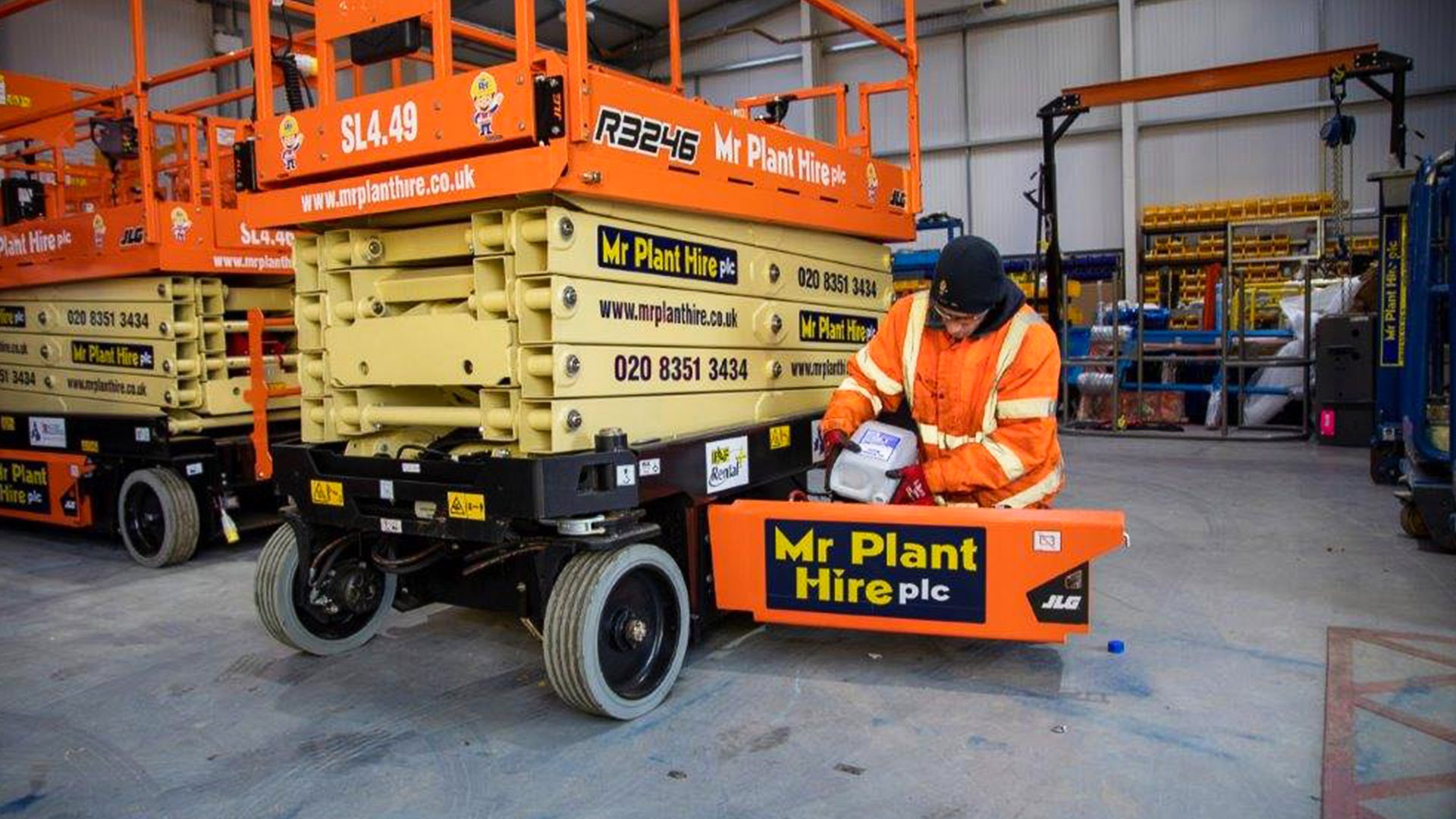 An engineer works on a Mr. Plant Hire lift.