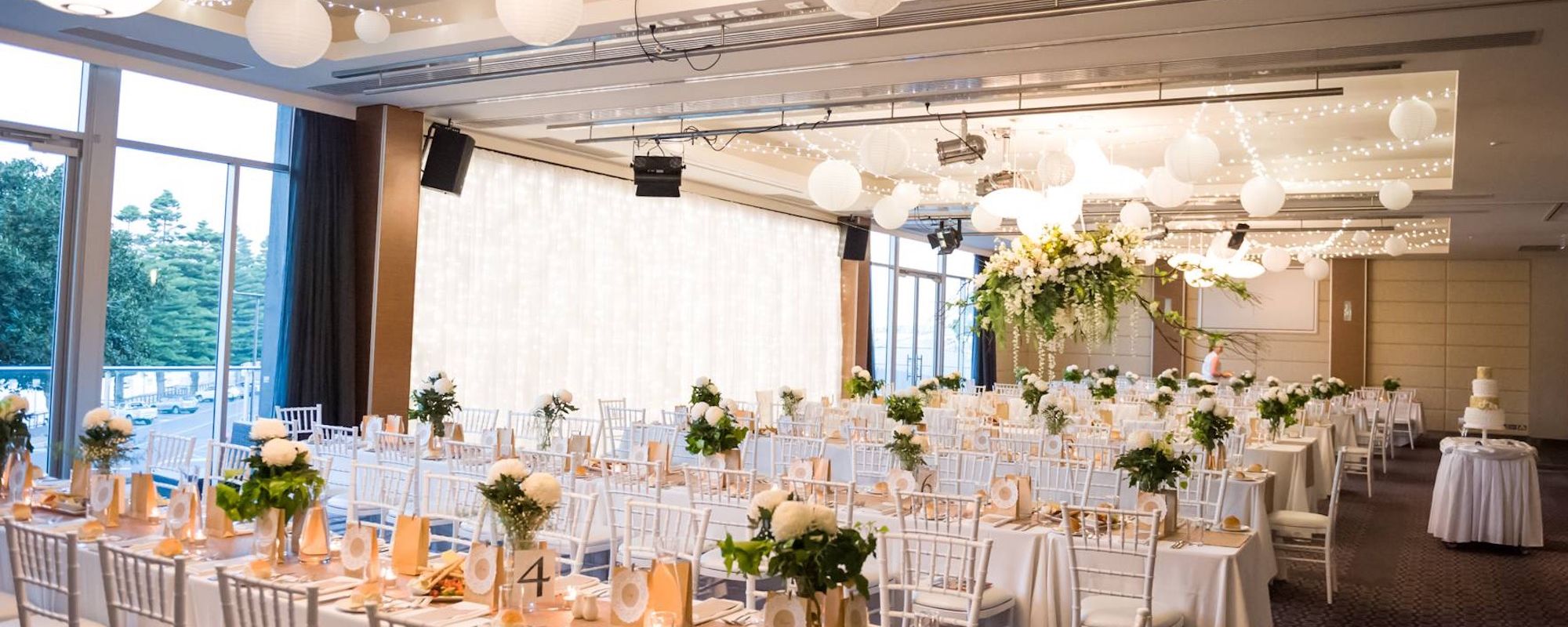 Wedding room set up in white with a glass wall letting in light.