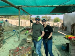 South Africa Regional Director Bernice Smith and her husband pose for a photo while making hundreds of bricks for Door of Hope, a South African charity.