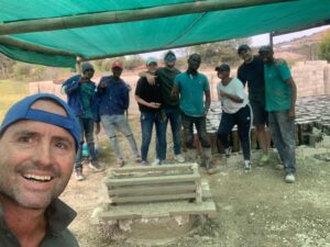 South Africa Regional Director Bernice Smith and her husband pose for a photo with several volunteers with a partner company while making hundreds of bricks for Door of Hope, a South African charity.