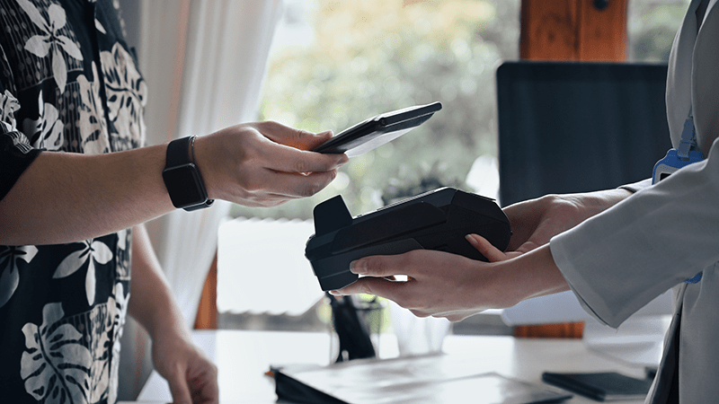 A customer pays a merchant via phone using an integrated payment system.