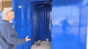 Screenshot-2024-12-18-at-102718 AM 1 - Point of Rental Software ZA | Hire & Inventory Management Software Doug Haas of Crown Rentals holds an extra-large blue rental locker door open.