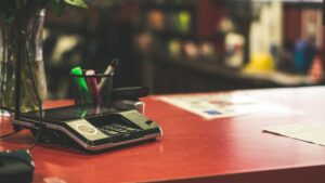 A payment device sits on a red rental counter.