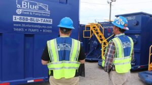A pair of Blue Tank & Pump employees inspect a tank.