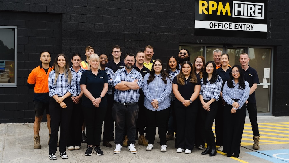 RPM Hire staff team photo outside their office. Roughly 20 men and women in RPM Hire shirts and work pants.