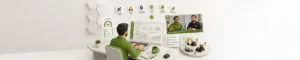Person at a white desk monitoring a green-themed asset management dashboard across several screens